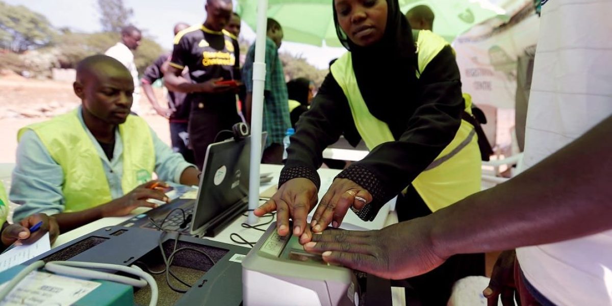 Officials from the Independent Electoral and Boundaries Commission (IEBC) records finger prints of a man as they collect data from the electorate during the launch of the 2017 general elections voter registration exercise within Kibera slums in Kenya's capital Nairobi, January 16, 2017. REUTERS/Thomas Mukoya - RTSVQJV